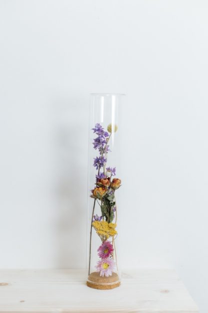 Gedroogde bloemen in glazen stolp